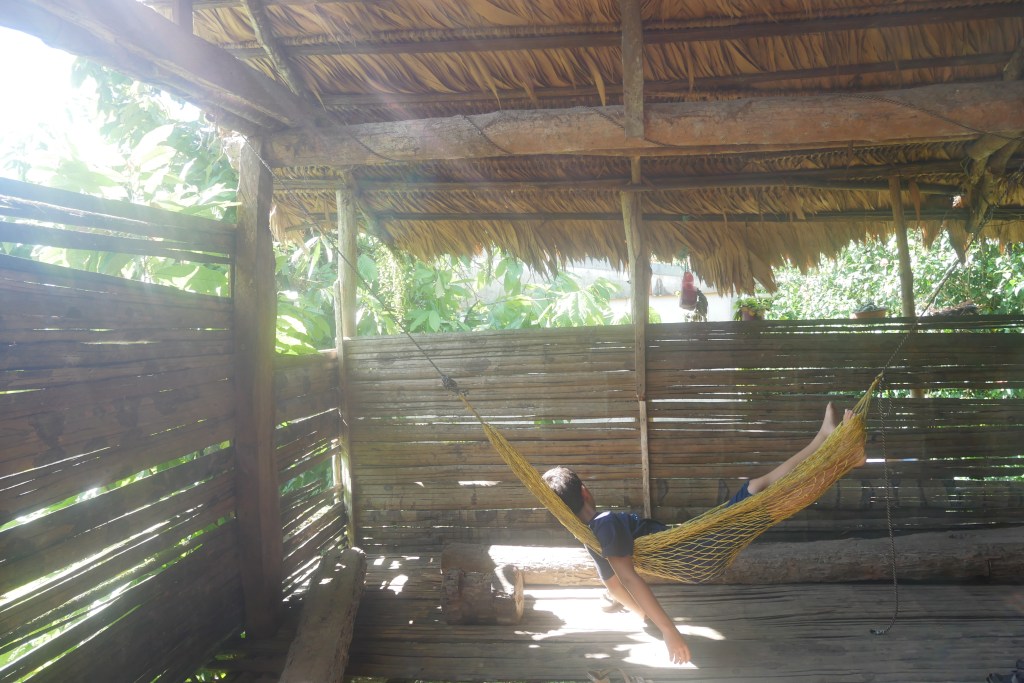 Enfant couché dans un hamac dans une hutte