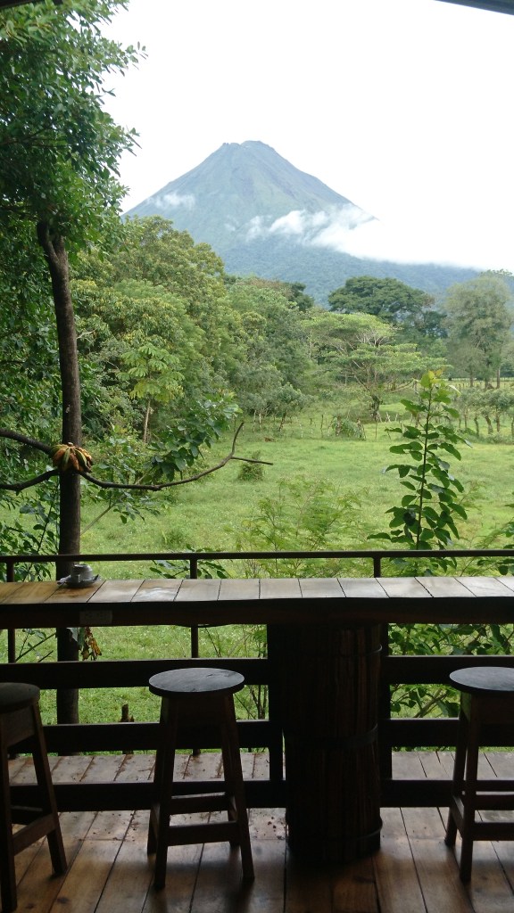 Tabourets et comptoir sur une terrasse avec vue sur le volcan Arenal