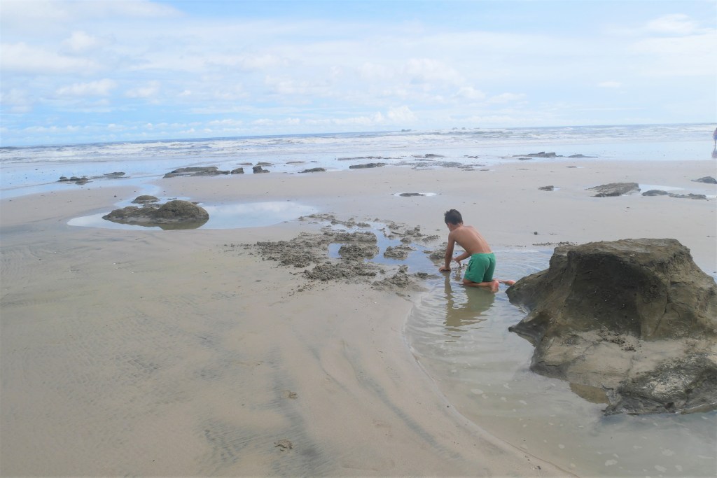 Enfant jouant sur la plage avec l'eau