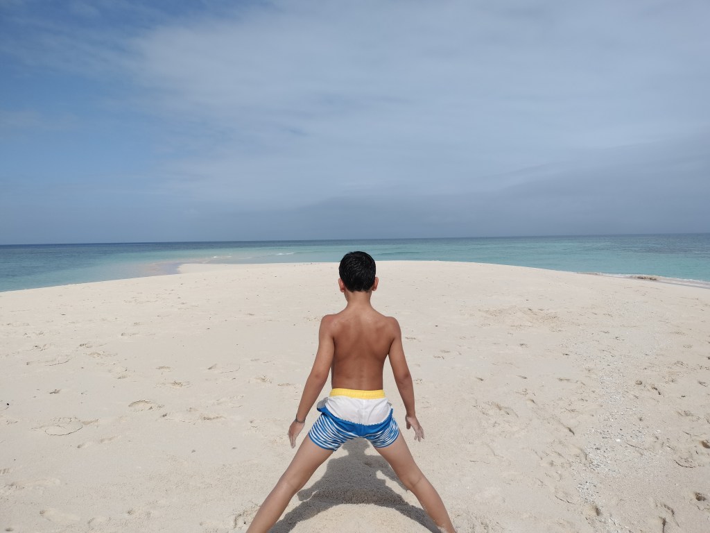 Enfant sur ilot de sable blanc